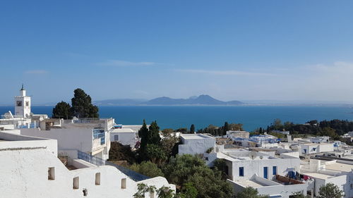 High angle view of town by sea against sky