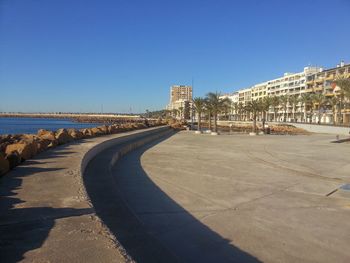 Empty road against clear blue sky