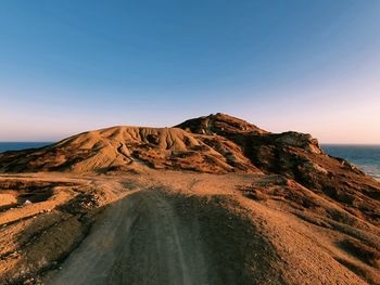 Scenic view of sea and mountains against clear sky