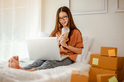 Young woman using mobile phone at home