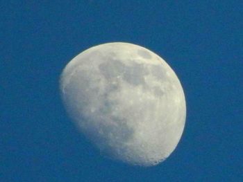 Low angle view of moon against blue sky