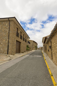 Road amidst buildings against sky