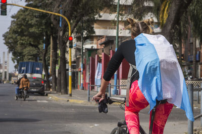 Woman with umbrella on road in city