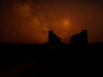 Silhouette buildings against sky at night