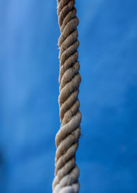 Low angle view of rope tied up against blue sky
