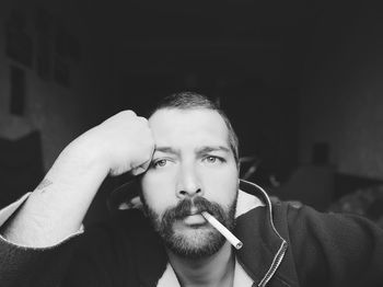 Portrait of man smoking while sitting at home