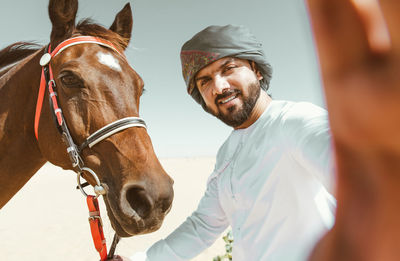 Portrait of man taking selfie with horse