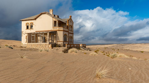 An abandoned home in kolmanskop lies surrendered to the desert.