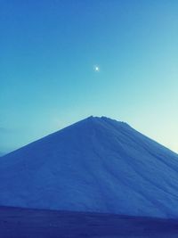 Scenic view of snowcapped mountain against blue sky