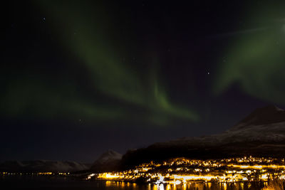 Illuminated city against sky at night