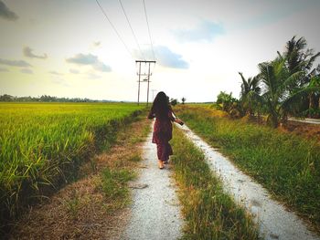 Rear view of woman walking on footpath