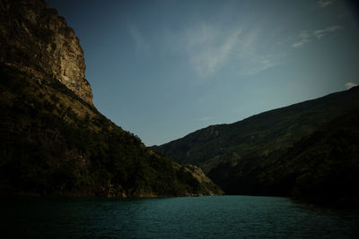 Scenic view of sea and mountains against sky