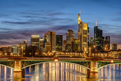 Illuminated city buildings against sky