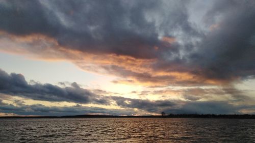 Scenic view of sea against dramatic sky during sunset