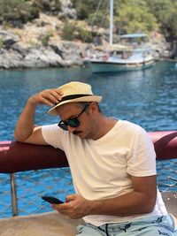 Young man sitting on boat in water