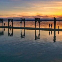 Pier on sea at sunset