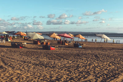 Beach umbrellas by sea against sky