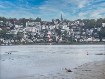 Scenic view of sea by buildings against sky