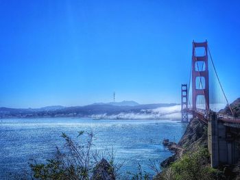 View of suspension bridge against blue sky