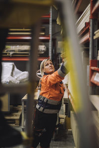 Mature female carpenter working in warehouse