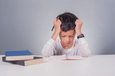 Portrait of boy sitting on table