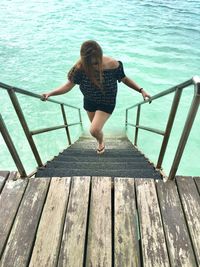 Full length of woman standing on pier over sea