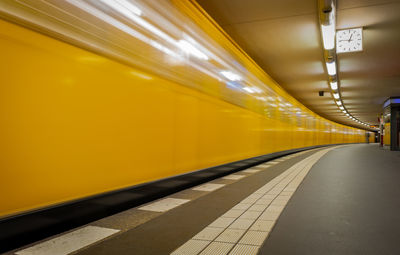 Blurred motion of yellow train at railroad station