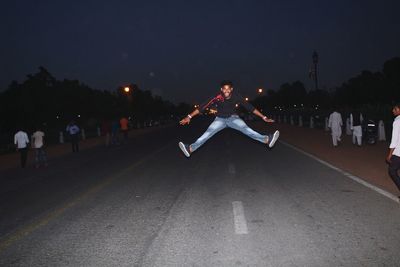 Full length portrait of man jumping on road