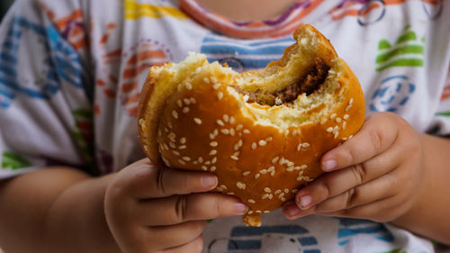 Close-up of hand holding hamburger