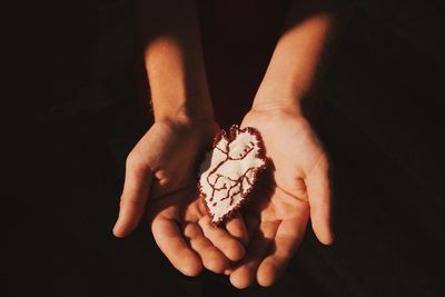 Cropped image of hand holding over black background