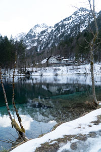 Scenic view of lake by snowcapped mountains against sky