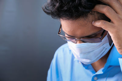 Close-up of doctor wearing flu mask sitting at hospital