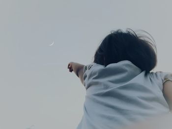 Rear view of woman standing against clear sky
