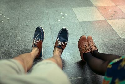 Low section of man and woman sitting on street