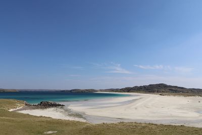 Scenic view of beach against blue sky