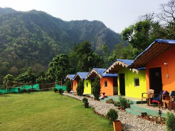 Houses by trees and mountains against sky