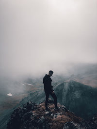 Man standing on mountain against sky