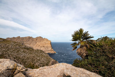 Rock formations by sea against sky