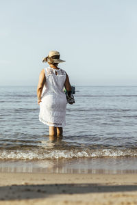 Senior woman wading in the sea, el roc de sant gaieta, spain