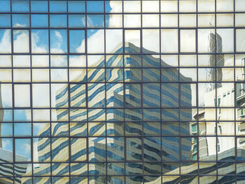 Low angle view of glass building against sky