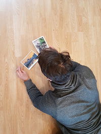 High angle view of child wearing hat on hardwood floor