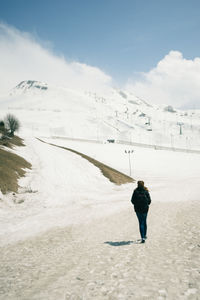 Man working on beach against sky