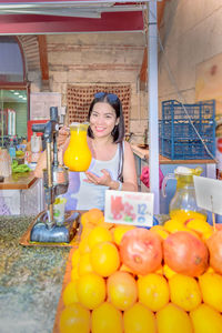 Portrait of smiling woman juice while standing in market