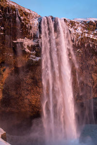 Scenic view of waterfall against sky