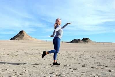 Full length of young woman standing on beach