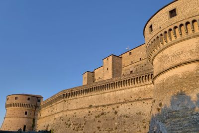 Low angle view of historical building against clear blue sky