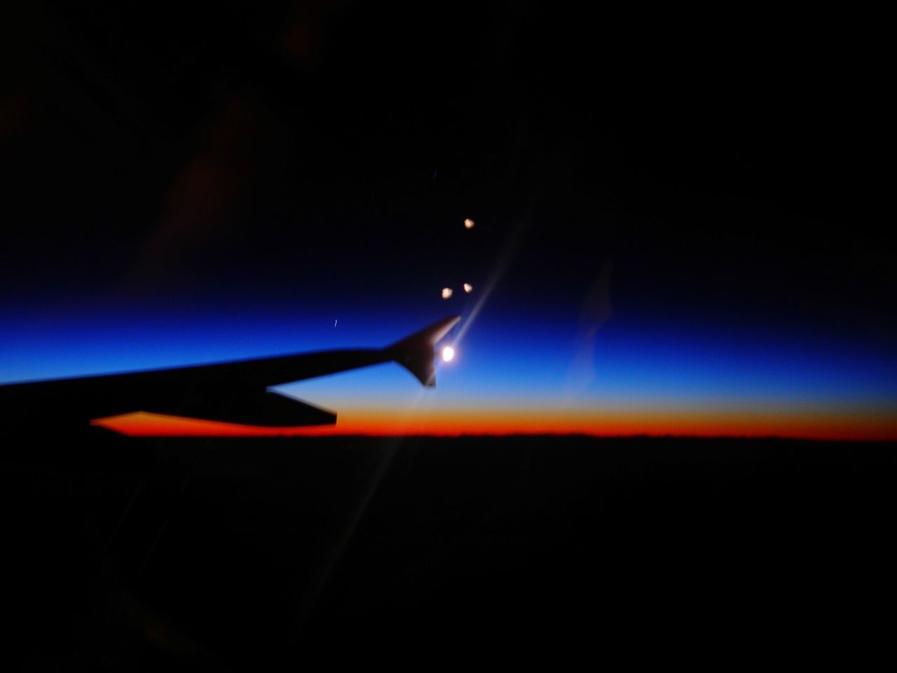 AIRPLANE AGAINST SKY AT NIGHT