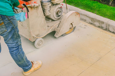 Low section of man with machinery standing on footpath