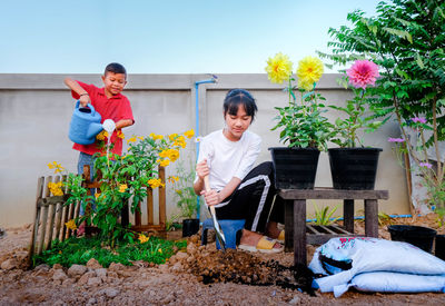 Activities take children to plant trees boy and girl's help each other plant trees and flowers