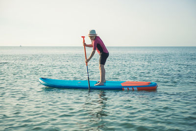 Man on boat in sea against clear sky